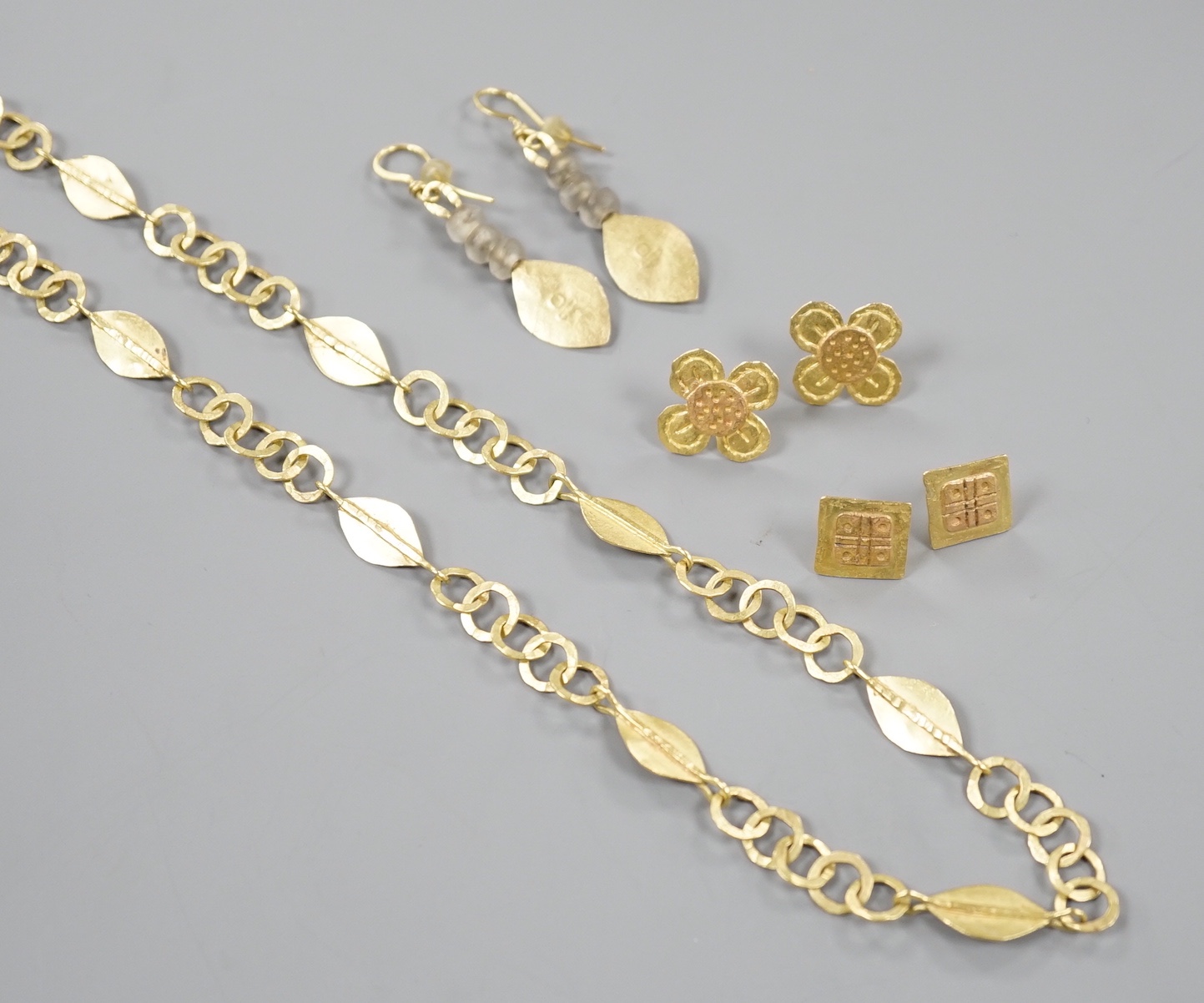 A modernist 18ct gold necklace, maker GR, London, 1999, 52cm, a pair of later drop earrings by the same maker and two other pairs of yellow metal ear studs, stamped GR only
